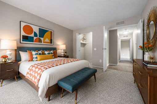 Spacious bedroom with teal accents and geometric artwork at Village Club of Farmington Hills Apartments, Farmington Hills, MI