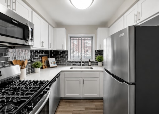 A modern kitchen with a black stove top oven and a black refrigerator.