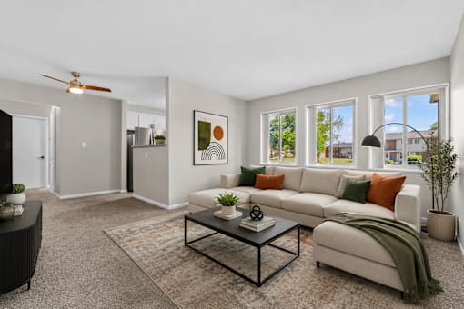 A living room with a white couch, a coffee table, and a rug.