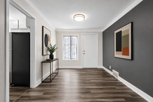 A hallway with a black framed mirror on the wall.