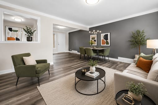 A living room with a green armchair, a black coffee table, and a white sofa.