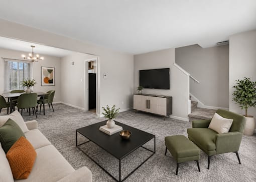 A living room with a white couch, a green armchair, and a black coffee table.
