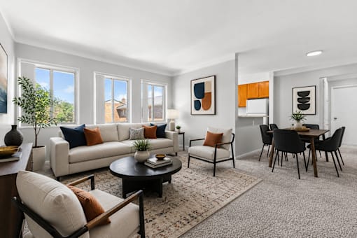 A living room with a white couch, a coffee table, and a dining table.