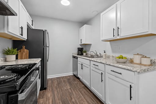 A kitchen with white cabinets and a black stove top oven.