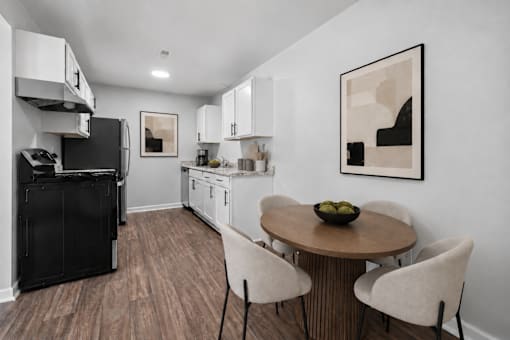 A kitchen with a black fridge and white cabinets.