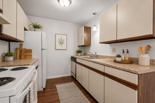 A kitchen with white appliances and wooden cabinets.