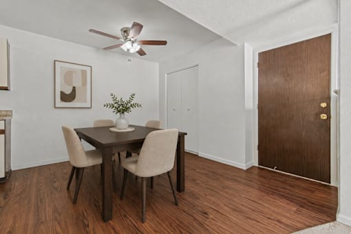 A dining room with a table and chairs.
