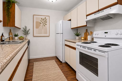 A kitchen with a white stove top oven and a white refrigerator.