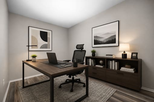 A modern home office with a laptop on the desk and a framed picture on the wall.