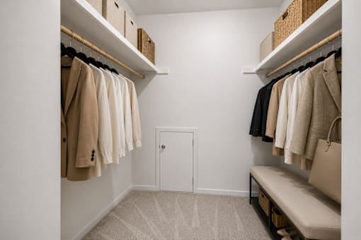 A hallway with a bench and coats hanging on the wall.