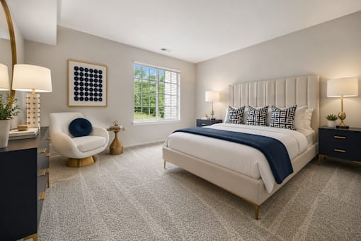 A bedroom with a large bed, a chair, and a painting on the wall.