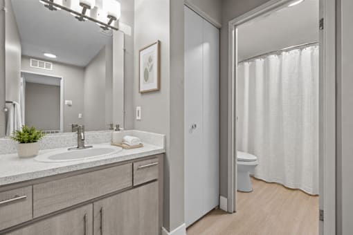 Modern bathroom with granite vanity and private water closet at Village Club of Farmington Hills Apartments, Farmington Hills, MI 48331