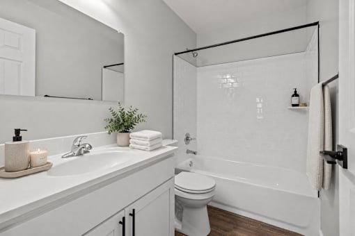A white bathroom with a toilet, sink, and bathtub.