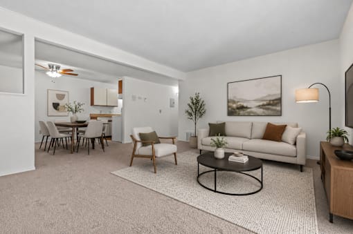 A living room with a couch, chairs, and a coffee table.