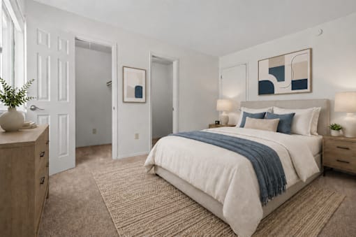 A bedroom with a large bed and a wooden dresser.