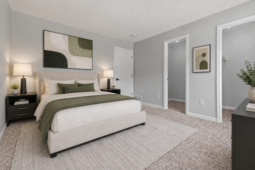 A bedroom with a large bed and a painting on the wall.