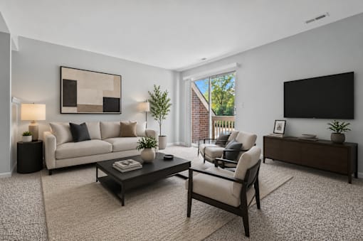 A modern living room with a white couch, a coffee table, and a flat-screen TV.