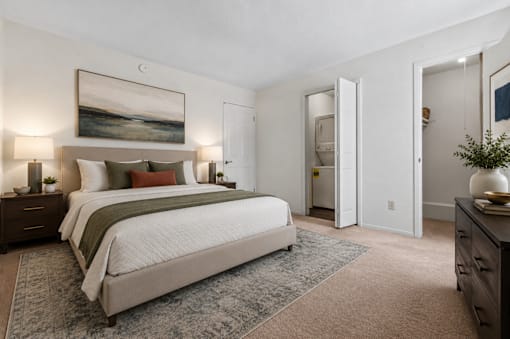 A bedroom with a large bed and a painting on the wall.