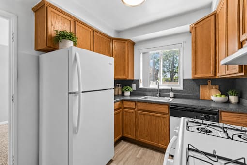 A white refrigerator stands in a kitchen with wooden cabinets.