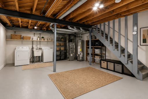 A room with a staircase and a washer and dryer.