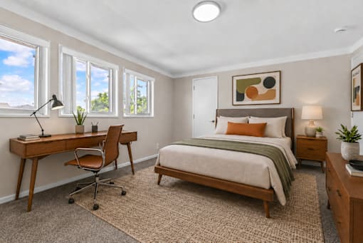 A bedroom with a bed, desk, and chair.