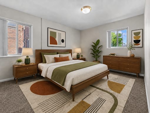 A bedroom with a large bed and a rug on the floor.