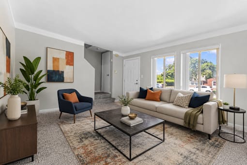 A living room with a blue chair and a white couch.