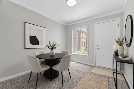 A dining room with a table and chairs.