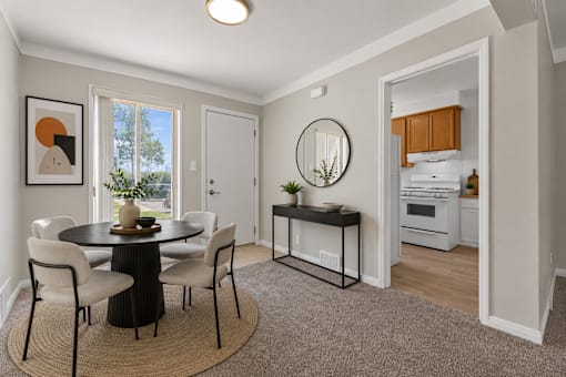 A dining room with a round table and chairs.