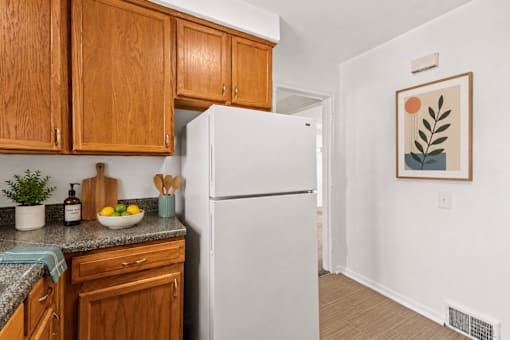 A kitchen with wooden cabinets and a white refrigerator.