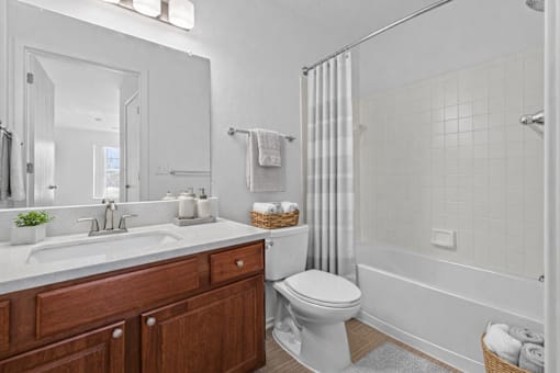 A white bathroom with a toilet, sink, and shower.