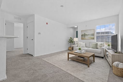 A living room with a white couch and a coffee table.
