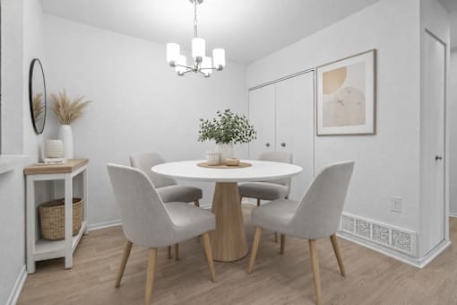 A dining room with a white table and chairs.