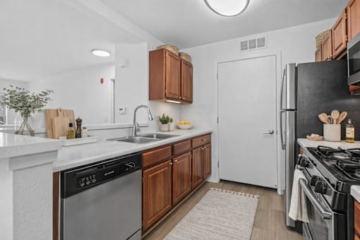 A modern kitchen with wooden cabinets and stainless steel appliances.