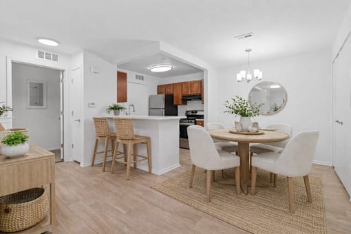 A kitchen with a dining table and chairs.