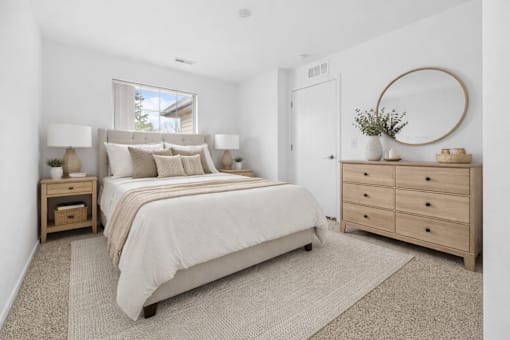 A bedroom with a large bed, a dresser, and a window.