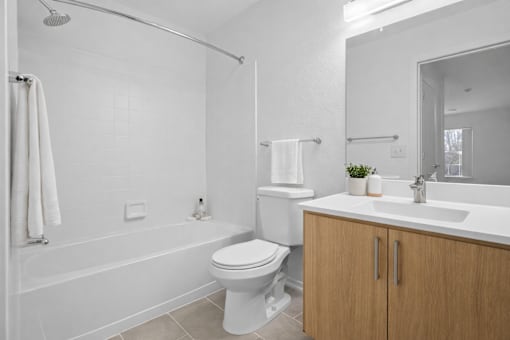 A white bathroom with a toilet, sink, and bathtub.