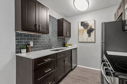 A kitchen with dark brown cabinets and a white countertop.