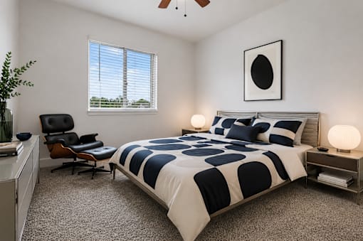 A bedroom with a bed, chair, and a ceiling fan.
