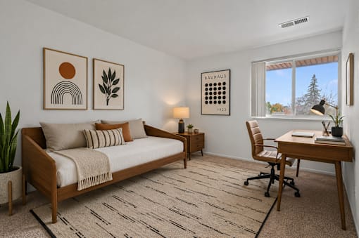 A bedroom with a bed, desk, and chair.