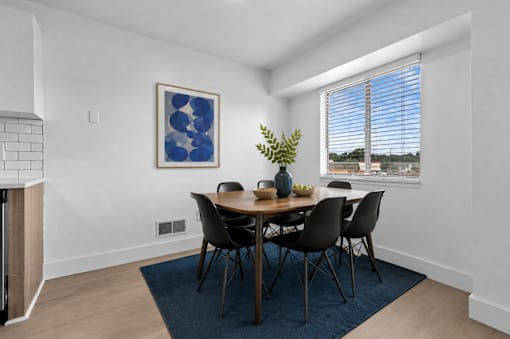 A dining room with a table set for four.