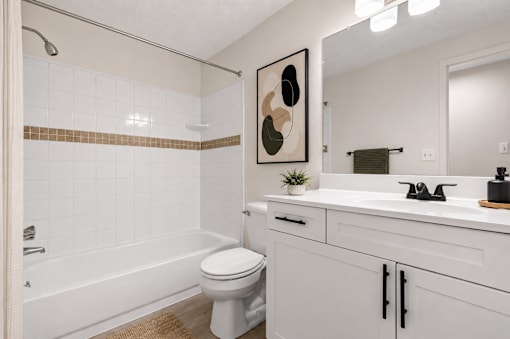 A white bathroom with a toilet, sink, and bathtub.