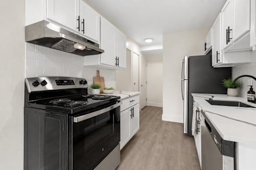 A modern kitchen with black appliances and white cabinets.