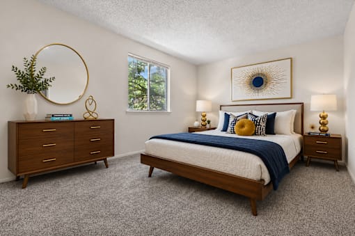 A bedroom with a bed, dresser, and nightstand.