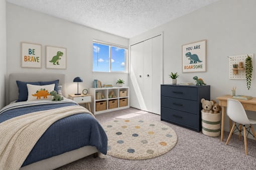 A bedroom with a bed, desk, and a rug with a dinosaur print.