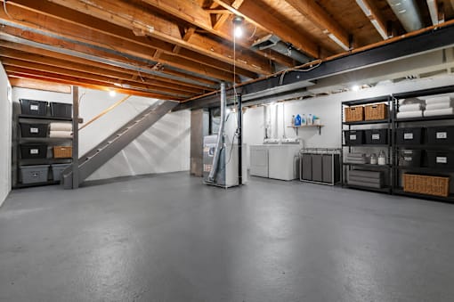 A spacious basement with a concrete floor and a staircase leading to the upper level.