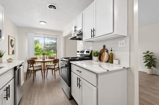 A modern kitchen with white cabinets and a wooden table.