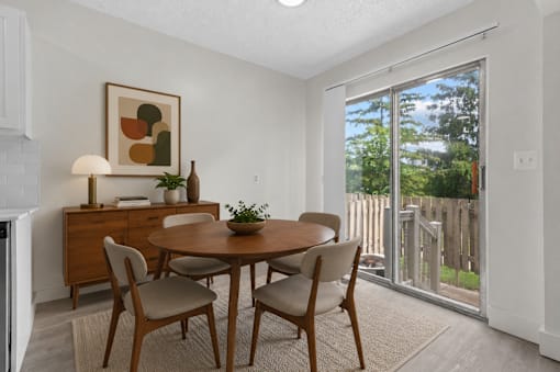 A dining room with a wooden table and chairs.