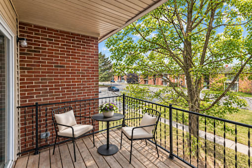 A balcony with a table and two chairs.