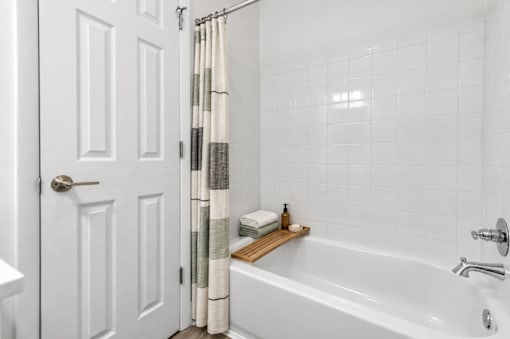 A white bathroom with a white tub and a white door.